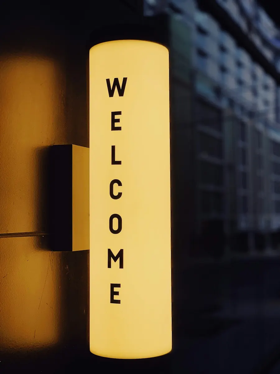 Enseigne lumineuse jaune « WELCOME » à l'entrée d'un immeuble, symbole d'un onboarding qui accueille vraiment les nouveaux collaborateurs